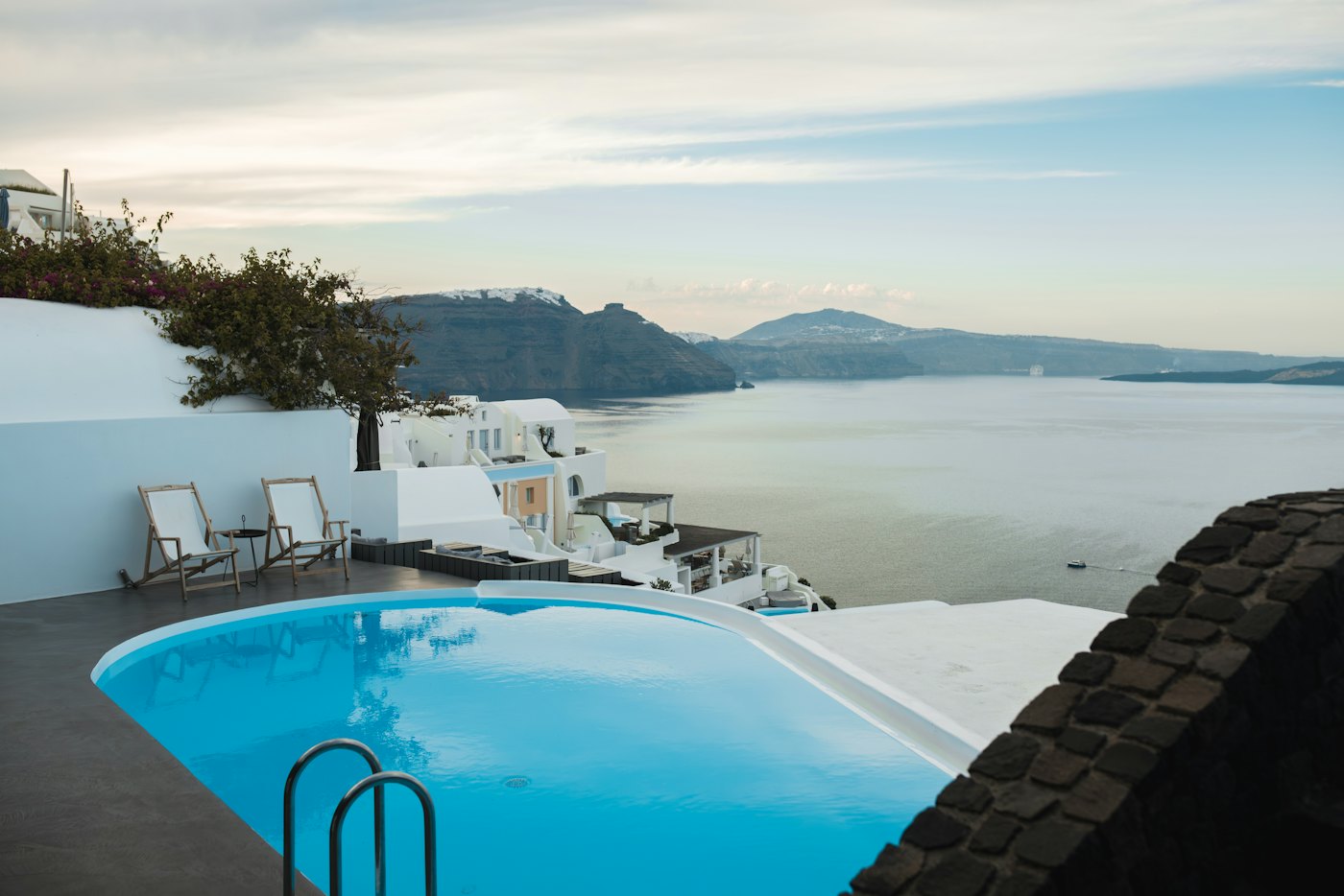 Terraza con piscina sobre el mar al atardecer